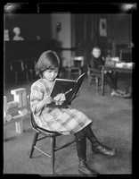 North School pupil reading, ca. 1920
